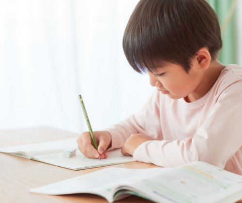 机に向かって勉強する男児の画像