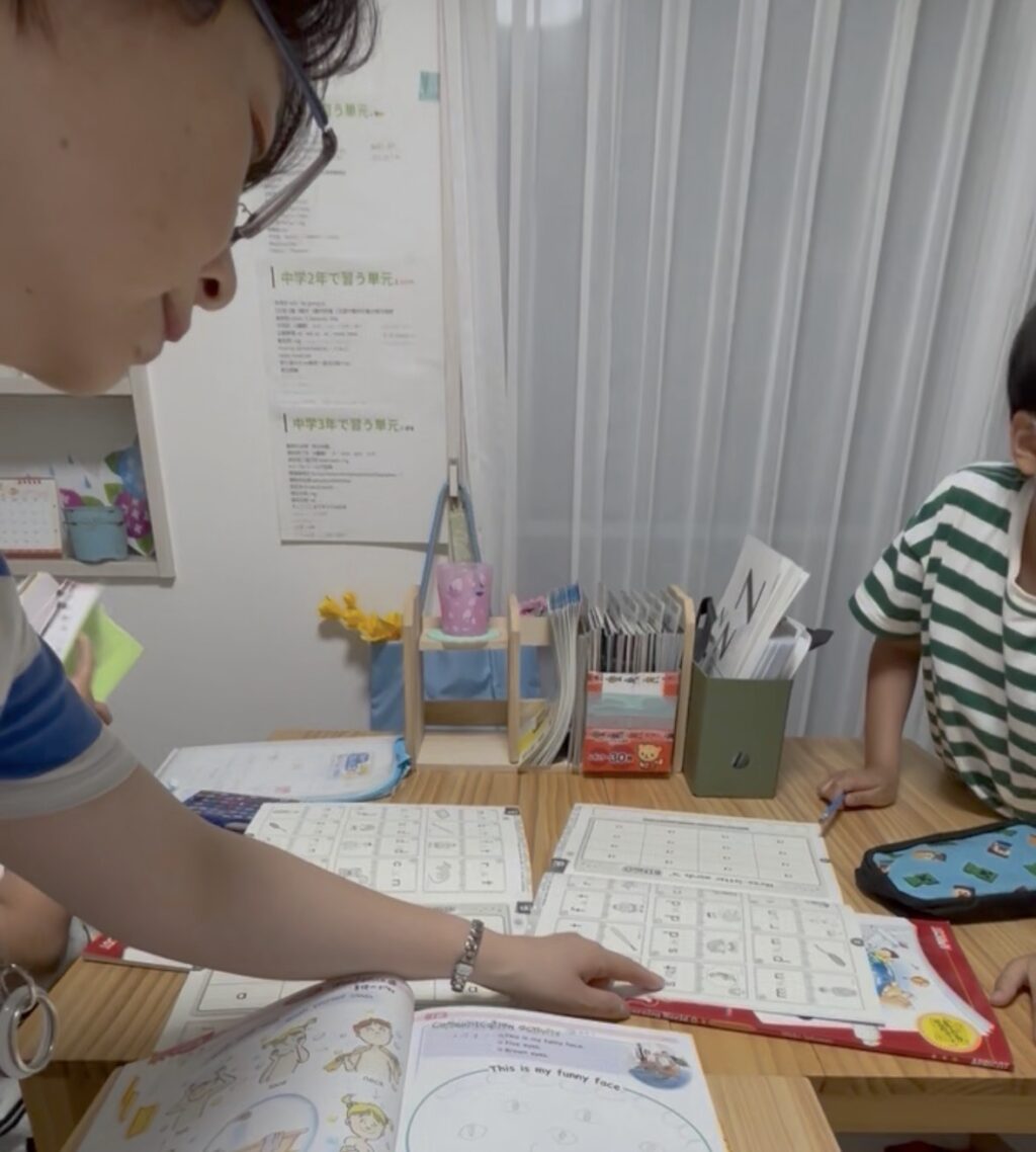 英語教室で教える講師と小学校５年生の生徒画像
