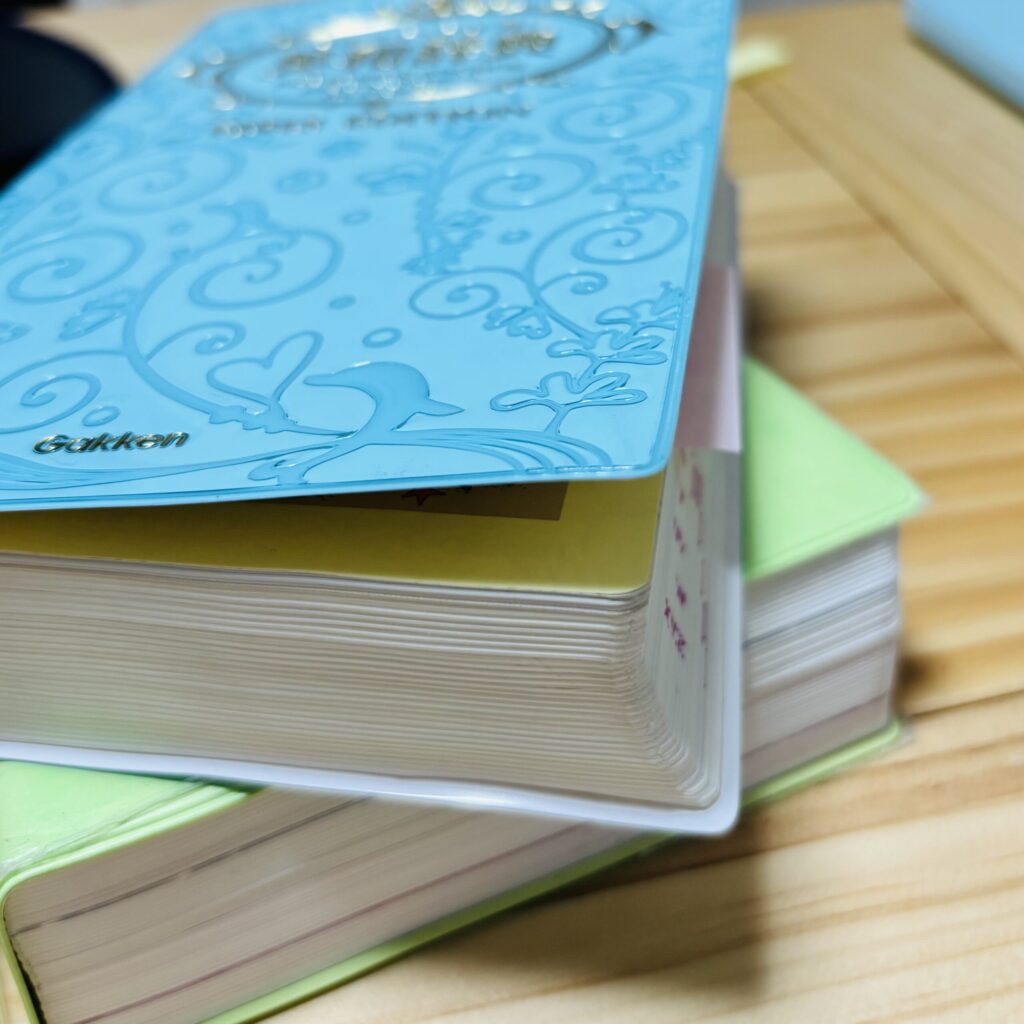 英和辞典（辞書）が机の上に重なって置いてある画像
